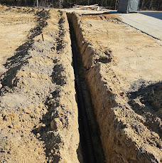Long, deep drainage trench excavated in sandy soil
